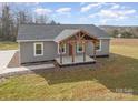 Attractive single-story home showcasing a covered wooden porch and low maintenance landscaping on a sunny day at 8255 W Nc 10 Hwy, Vale, NC 28168