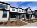 Modern townhome showcases a covered front porch, black window trim, complementary landscaping and stylish architectural design at 133 Armstrong Rd, Belmont, NC 28012