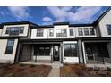 Townhome featuring a welcoming front porch, complemented by dark window frames and attractive modern landscaping at 133 Armstrong Rd, Belmont, NC 28012