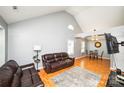 Living room featuring hardwood floors, vaulted ceilings, and brown leather furniture at 4816 Windchase Ln, Charlotte, NC 28269