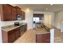 Modern kitchen with stainless steel appliances, granite countertops, and rich wood cabinetry at 1009 Dawn Light Rd, Indian Trail, NC 28079