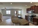 Open kitchen view featuring granite countertops, stainless appliances, and seamless flow into the living area at 1009 Dawn Light Rd, Indian Trail, NC 28079