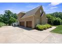 Spacious three-car garage with an expansive driveway and lush, mature landscaping at 122 Long Cove Ln, Mooresville, NC 28117