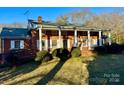 Brick house with a large front porch and mature landscaping at 1506 Dallas Cherryville Hwy, Dallas, NC 28034