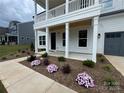 Charming two-story home showcasing a covered front porch and nicely landscaped yard at 2027 Cedar Falls Dr # 75, Waxhaw, NC 28173