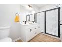 Modern bathroom with double vanity, white cabinets, black hardware, and glass-enclosed shower at 1011 Indiana St, Kannapolis, NC 28083