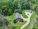 An aerial view of a unique brick home with a black metal roof and a detached garage at 6620 Old Concord Rd, Salisbury, NC 28146