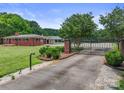 Gated entry with brick columns and lush landscaping leading to a beautiful red brick home at 6620 Old Concord Rd, Salisbury, NC 28146