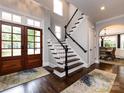 Two-story foyer with hardwood floors, staircase, and double doors at 4409 Solemn Point Ln, Charlotte, NC 28216