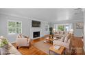 Virtually staged living room with hardwood floors, fireplace and French doors at 1626 S Wendover Rd, Charlotte, NC 28211