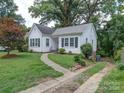 White house with black shutters, stone walkway, and driveway at 705 Neil St, Gastonia, NC 28052