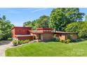 Beautifully landscaped modern home featuring red wood, brick accents, and a lush green lawn at 640 Davie Ave, Statesville, NC 28677
