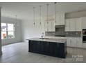 Bright kitchen featuring a large island, stainless steel appliances, and sleek white cabinetry at 5209 Mint Harbor Way # 0352, Charlotte, NC 28269