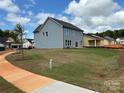 Landscaped backyard with green grass and a walkway at 6018 Valehaven Pl # 0070, Charlotte, NC 28269