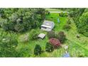 House nestled in a green landscape with a detached workshop and solar panels at 7507 Waxhaw Creek Rd, Waxhaw, NC 28173