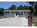 Charming ranch home with gray brick exterior, black shutters, and a brick-fenced yard at 4230 Northaven Dr, Charlotte, NC 28206