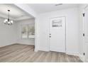 Bright entryway featuring hardwood floors, a modern chandelier, and a sleek front door with glass window at 6201 Long Branch Rd, Salisbury, NC 28147