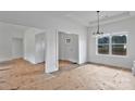 Bright living room featuring fresh white paint, large window, and modern chandelier, exuding a minimalist aesthetic at 6201 Long Branch Rd, Salisbury, NC 28147