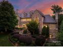 Stone chateau with manicured landscaping at dusk at 4536 Fox Brook Ln, Charlotte, NC 28211