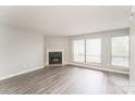 This living room features a corner fireplace, hardwood floors, and an abundance of natural light from the windows at 1600 Sharon W Rd # 11, Charlotte, NC 28210