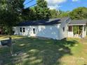 Charming single-story home exterior with white siding, dark roof, green lawn and landscaping at 702 N 9Th St, Bessemer City, NC 28016
