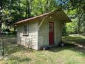 Small wooden shed with red door and single window at 1451 York Rd, Kings Mountain, NC 28086