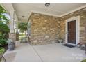 Stone front porch with seating and decorative planters at 4043 Orchid Way, Tega Cay, SC 29708