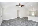 Bright living room features a vaulted ceiling, gray laminate flooring, and a modern ceiling fan at 6217 Long Branch Rd, Salisbury, NC 28147