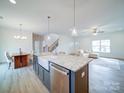 Modern kitchen with a farmhouse sink, granite countertops, and stainless steel appliances at 2613 Plyler Mill Rd, Monroe, NC 28112