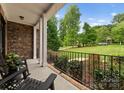 Inviting covered porch with stone accents, black iron railings, and relaxing view of the lush lawn at 160 Northington Woods Dr, Mooresville, NC 28117