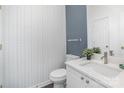 Updated powder room with patterned wallpaper, white vanity, and modern fixtures at 12229 Savannah Garden Dr, Charlotte, NC 28273