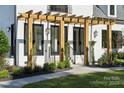 Detailed view of the wooden pergola and covered entrance of this gorgeous home at 18304 Rosapenny Rd, Charlotte, NC 28278