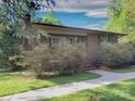Charming brick home with a well-manicured lawn, mature trees, and a quaint walkway at 3119 Hickory Hwy, Statesville, NC 28677