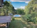 Expansive backyard featuring a fenced-in pool, surrounded by lush greenery and mature trees at 3119 Hickory Hwy, Statesville, NC 28677