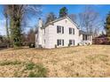 View of the side and rear of a two-story white brick home showing yard at 1628 Shannonhouse Dr, Charlotte, NC 28215