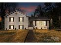 Charming white brick two-story home with black shutters at twilight at 1628 Shannonhouse Dr, Charlotte, NC 28215