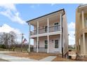 Charming two-story home featuring double porches with black railings and a light pink exterior at 5860 Pittmon Ln, Kannapolis, NC 28081