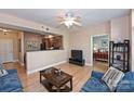 Open living room with hardwood floors, ceiling fan and view into kitchen at 1320 Fillmore Ave # 311, Charlotte, NC 28203