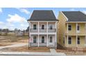 Charming two-story home featuring double balconies, white pillars, black railings, and a welcoming front entrance at 5830 Pittmon Ln, Kannapolis, NC 28081