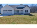Charming single-story home with a two-car garage, manicured lawn, and modern white siding at 9609 Stokes Ferry Rd, Gold Hill, NC 28071