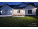 Charming single-story home with a two-car garage, manicured lawn, and modern white siding at 9609 Stokes Ferry Rd, Gold Hill, NC 28071
