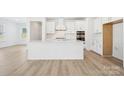 Modern, all-white kitchen featuring a center island, white cabinets, and stainless steel appliances at 121 Clawton Loop, Mooresville, NC 28115