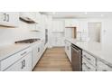 A modern white kitchen featuring stainless steel appliances, a gas cooktop, and a large island at 121 Clawton Loop, Mooresville, NC 28115