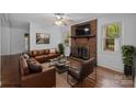 Living room with a brick fireplace, hardwood floors, and brown leather sectional sofa at 3338 Passmore Rd, Rock Hill, SC 29730