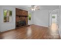 Bright living room showcasing a brick fireplace, wood floors, and a ceiling fan at 3338 Passmore Rd, Rock Hill, SC 29730