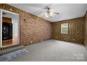 View of a bonus room showcasing carpet floors, brick wall, window and a ceiling fan at 3338 Passmore Rd, Rock Hill, SC 29730