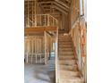 Interior framing of a new house showing an unfinished staircase leading to an upper level at 130 Falls Leaf Dr # Lot 4, Troutman, NC 28166