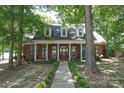 Charming brick home featuring a welcoming front porch, dormer windows, and a meticulously landscaped yard at 3814 Watson Church Rd, Monroe, NC 28110