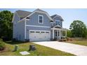 Two story home featuring a light blue exterior, two-car garage, and beautifully landscaped front yard at 4684 Hopsack Dr # Cal0105, Indian Trail, NC 28079