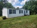 Single-story home featuring blue shutters, surrounded by a green lawn at 6261 Burnhurst Ln, Denver, NC 28037